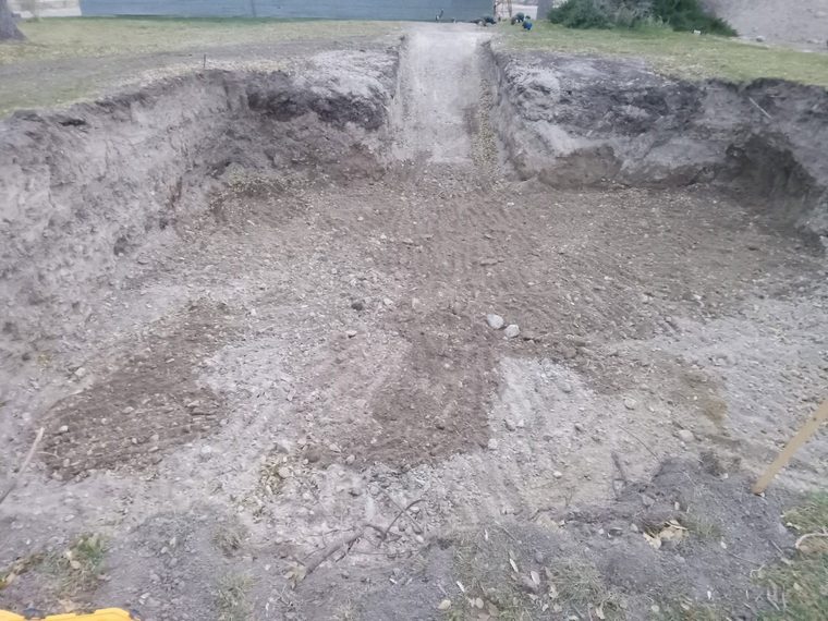 Basement excavation with an equipment ramp left in for access.