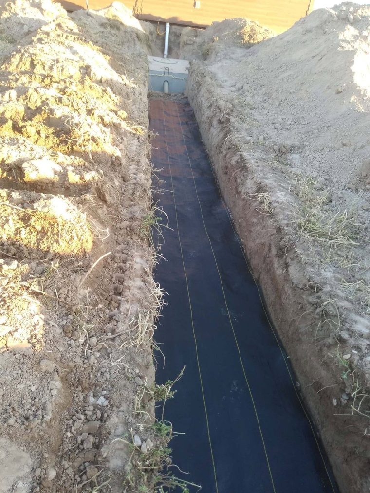 Drain field trench with fabric laid, running off the tank.
