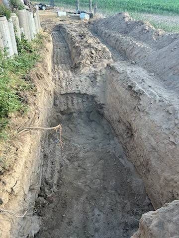 Utility trench cut alongside an existing structure.